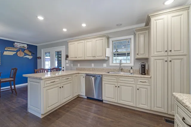 a kitchen with white cabinets and sink