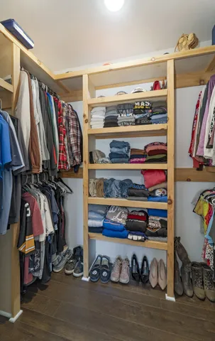 a view of walk in closet with clothes and shoes