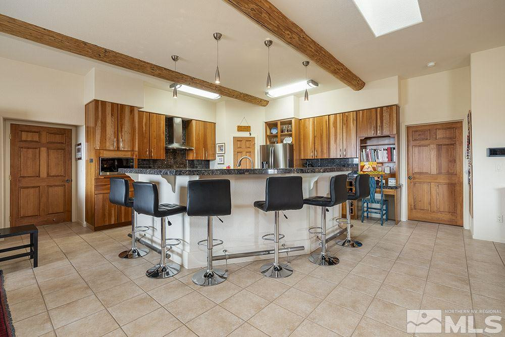 5340 Broken Spur Road Reno, NV 89510 - Photo 8 of 38 a kitchen with stainless steel appliances kitchen island granite countertop a refrigerator and chairs