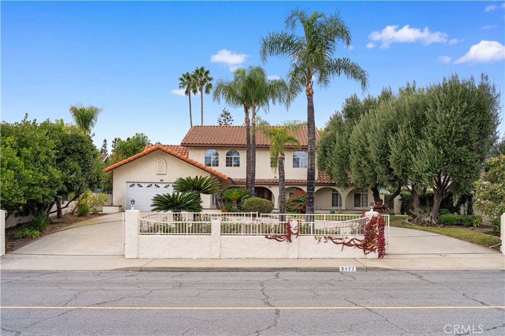 a view of a house with a yard and palm trees