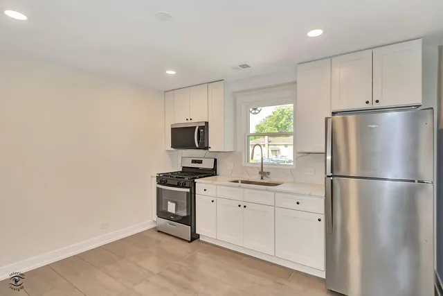 a kitchen with stainless steel appliances a refrigerator sink and cabinets