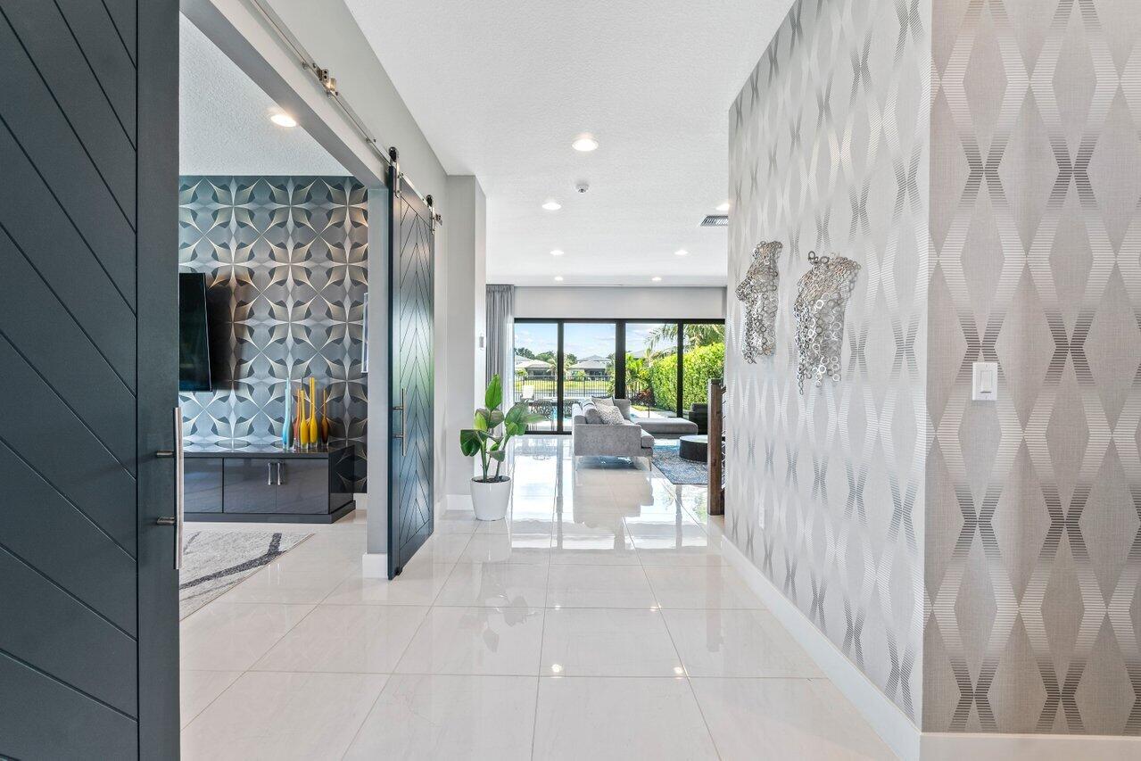 8618 Tower Bridge Court Boca Raton, FL 33496 - Photo 13 of 47 a view of a hallway with dining area and chandelier