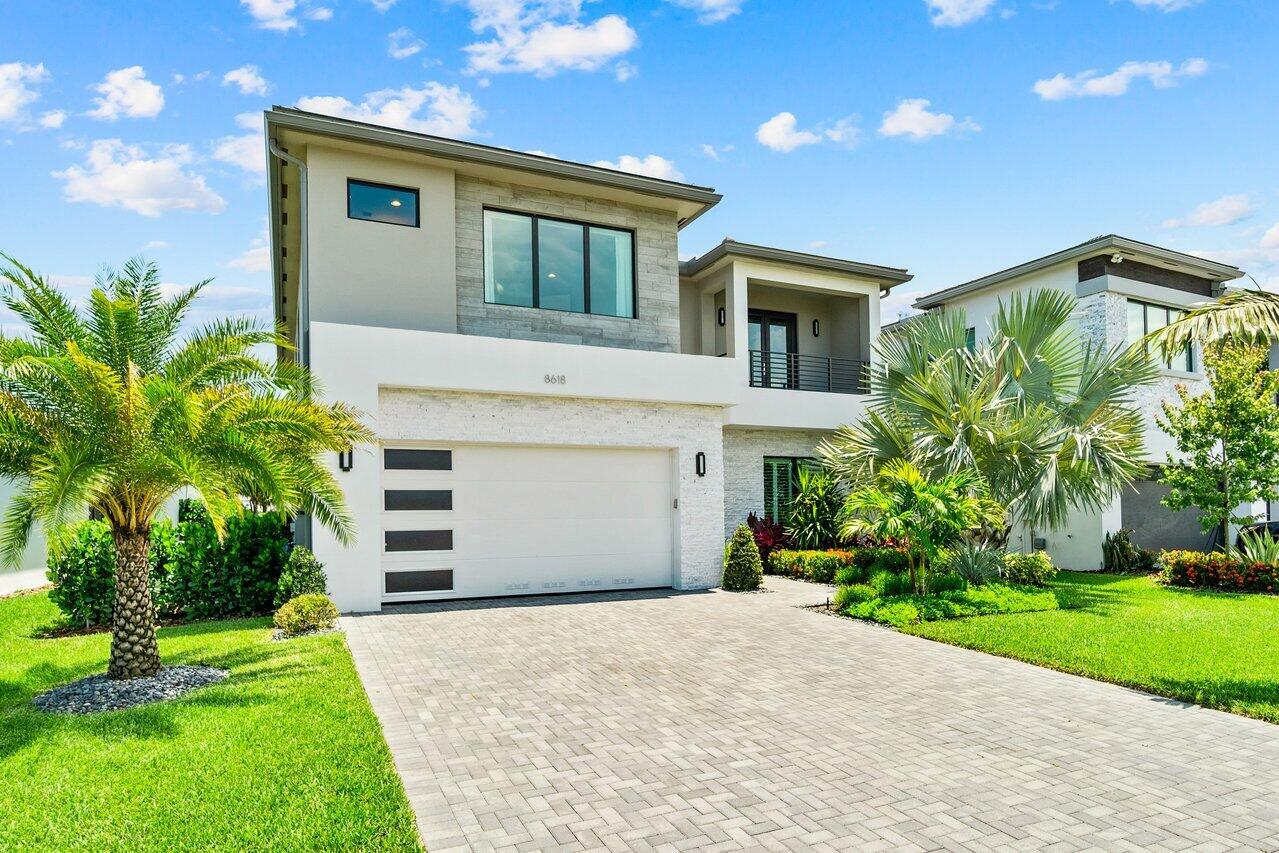 8618 Tower Bridge Court Boca Raton, FL 33496 - Photo 2 of 47 a front view of a house with a yard and garage