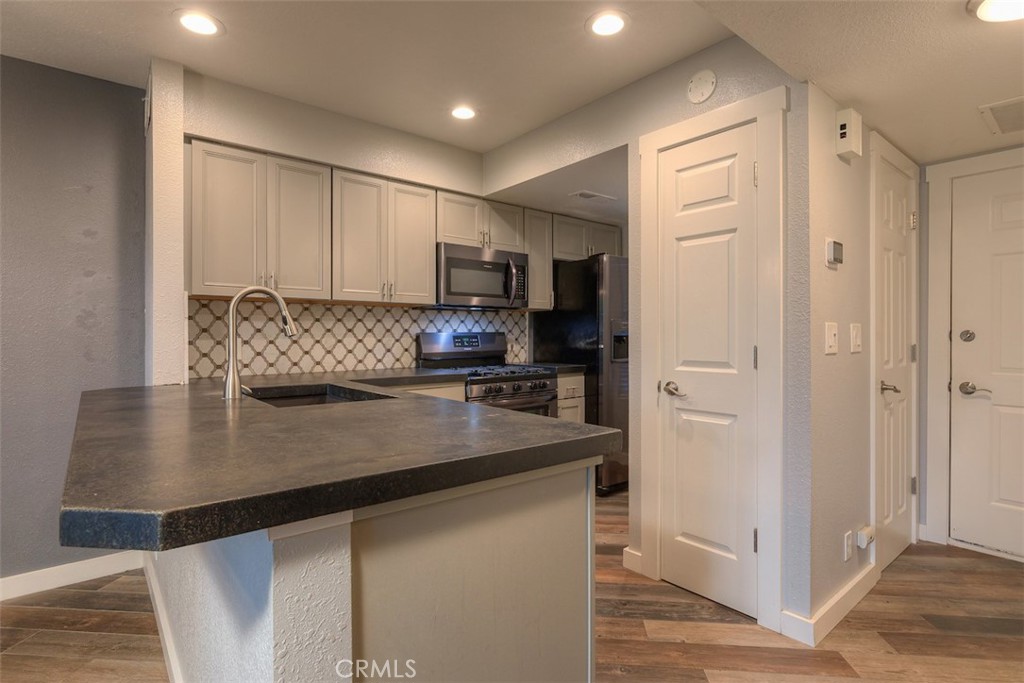 2910 Pennyroyal Drive Chico, CA 95928 - Photo 7 of 41 a kitchen with kitchen island a counter top space cabinets and stainless steel appliances