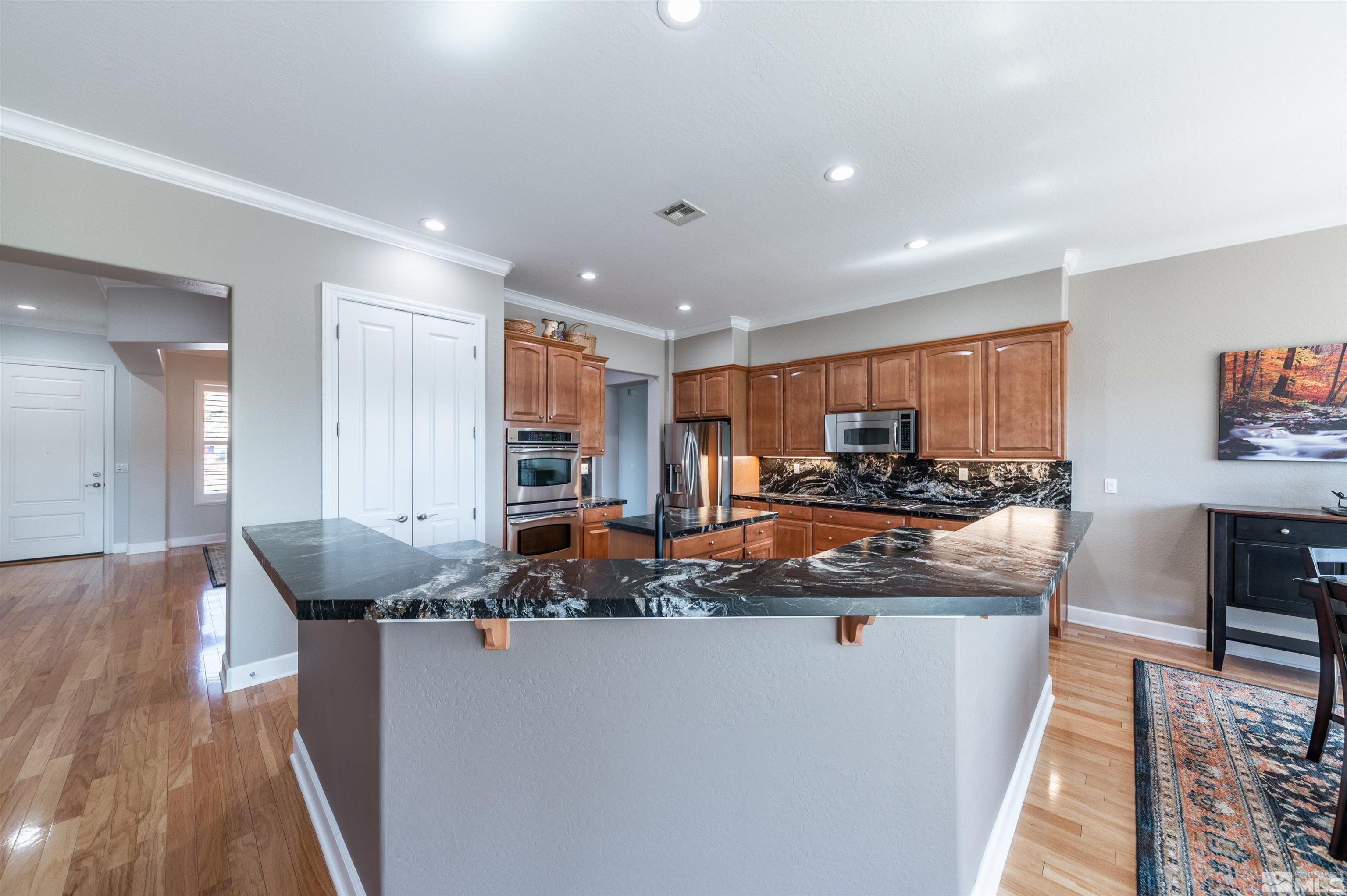 1291 Meridian Ranch Drive Reno, NV 89523 - Photo 8 of 30 a view of a room with kitchen island stainless steel appliances wooden floor and living room view