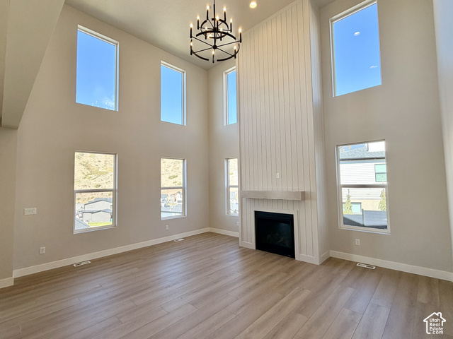 1595 West Canyon Rim Road, Unit 630 Lehi, UT 84048 - Photo 14 of 41 Vaulted ceilings with a prominent black chandelier, wood-finish flooring, and a fireplace with a light wood mantle