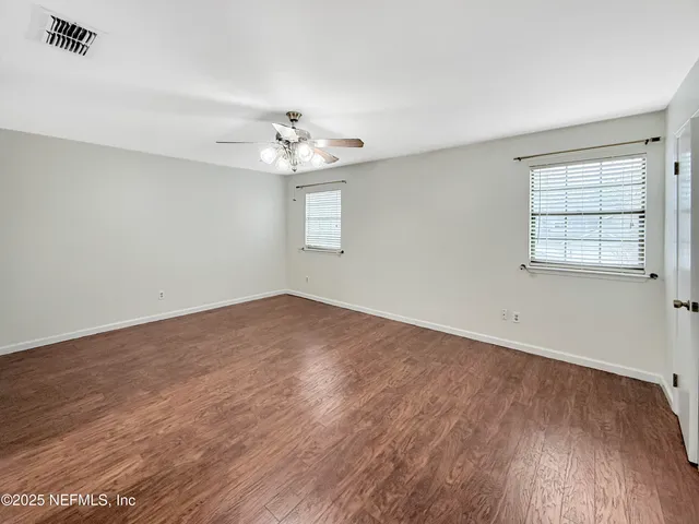 wooden floor in an empty room with a window