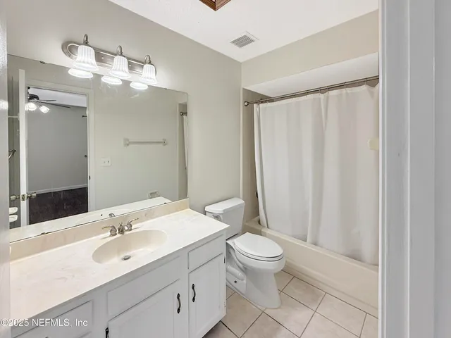 a bathroom with a sink a toilet a mirror and shower curtain