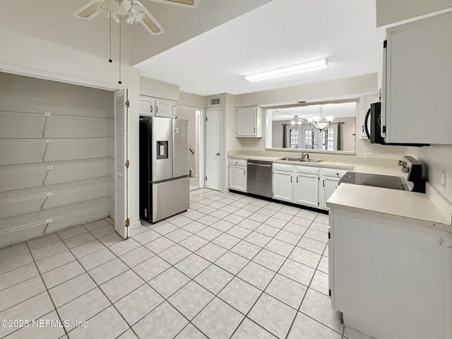 a kitchen with a refrigerator sink and cabinets