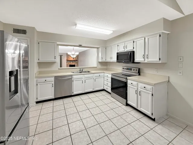 a kitchen with white cabinets stainless steel appliances and sink