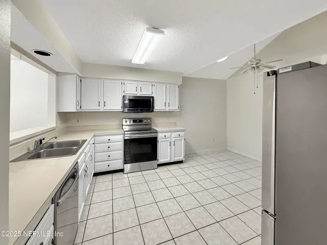 a kitchen with a sink a stove and cabinets