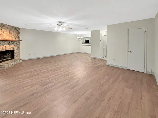 a view of empty room with wooden floor and fireplace