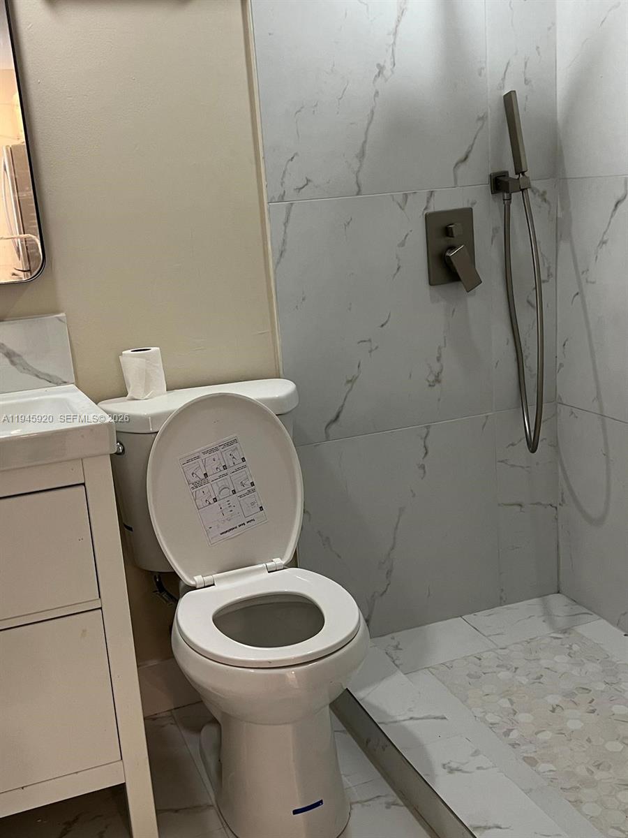 10801 Southwest 109th Court, Unit D110 Miami, FL 33176 - Photo 18 of 25 a white toilet sitting next to a bathroom sink and a granite floor
