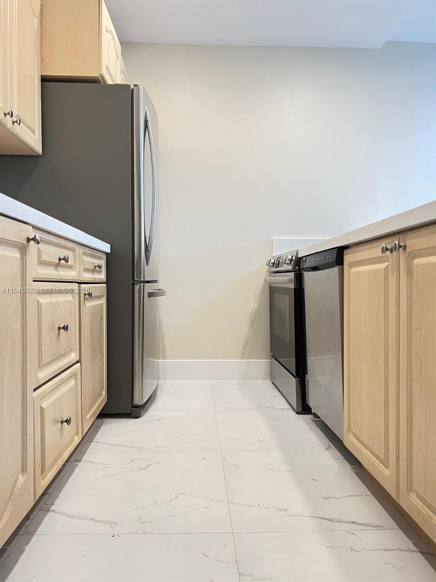 10801 Southwest 109th Court, Unit D110 Miami, FL 33176 - Photo 8 of 25 a kitchen with stainless steel appliances a refrigerator and a stove top oven