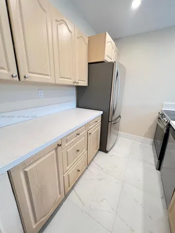 a kitchen with cabinets and a refrigerator