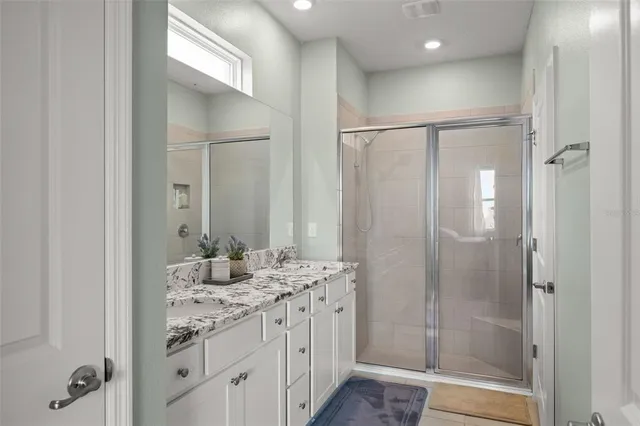 a bathroom with double vanity sinks and a shower