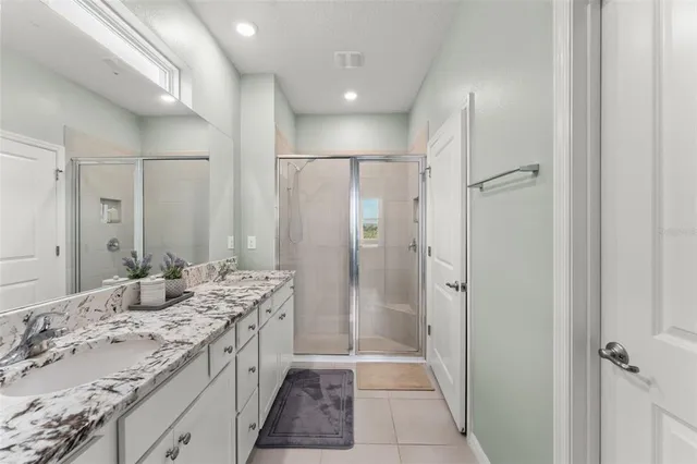 a spacious bathroom with a granite countertop sink mirror and shower