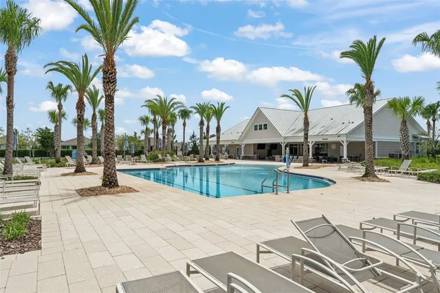a view of a swimming pool with tables and chairs