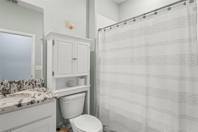 a bathroom with a granite countertop toilet sink and shower