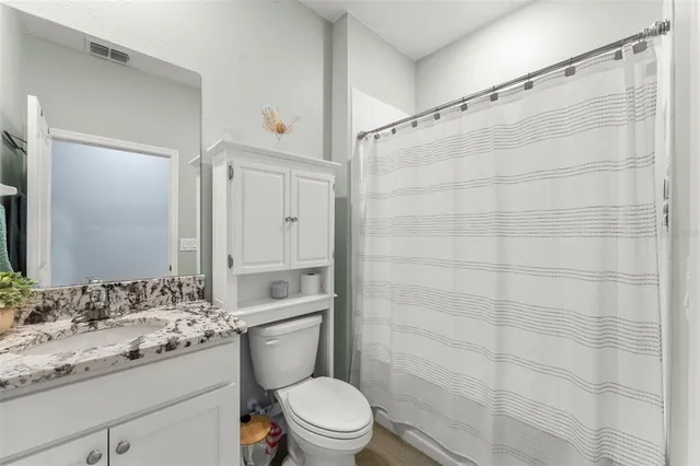 a bathroom with a granite countertop sink toilet and shower