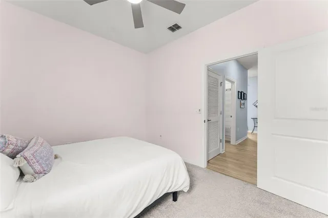 a bedroom with a bed and a ceiling fan