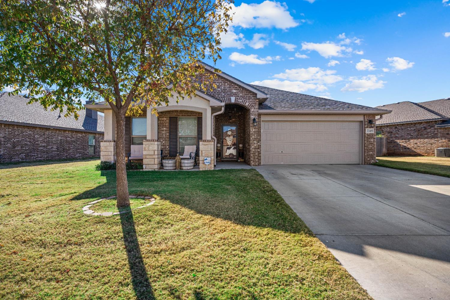 7349 100th Street Lubbock, TX 79424 - Photo 1 of 21 a front view of a house with garden