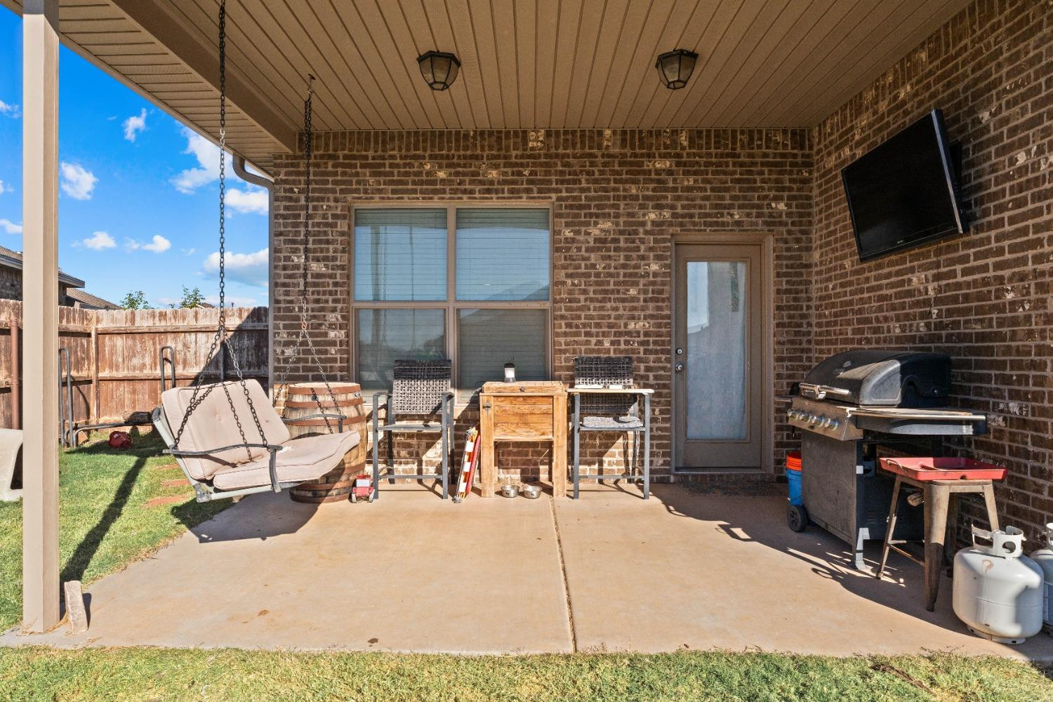 7349 100th Street Lubbock, TX 79424 - Photo 20 of 21 a view of a patio with table and chairs a barbeque grill with wooden fence