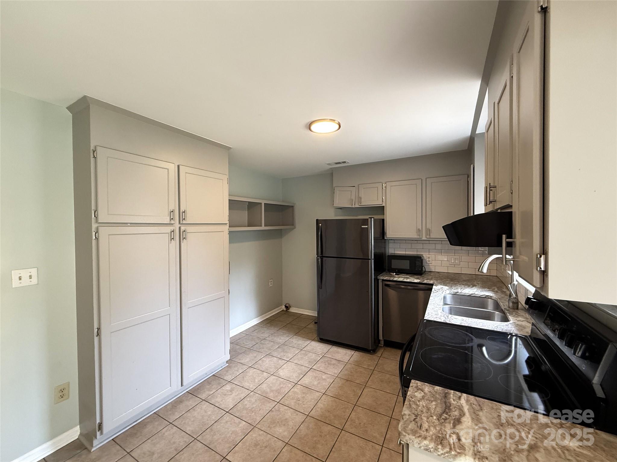420 Beaty Street Davidson, NC 28036 - Photo 5 of 15 a kitchen with a refrigerator and a stove