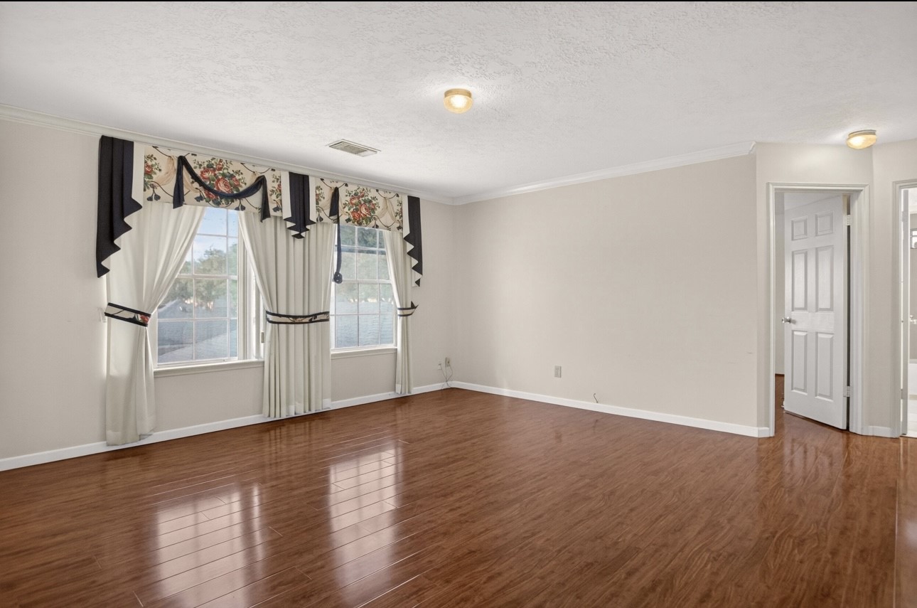 14731 Ridgechase Lane Houston, TX 77014 - Photo 27 of 37 an empty room with wooden floor and windows