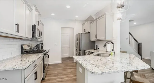 a kitchen with stainless steel appliances granite countertop a sink stove and refrigerator