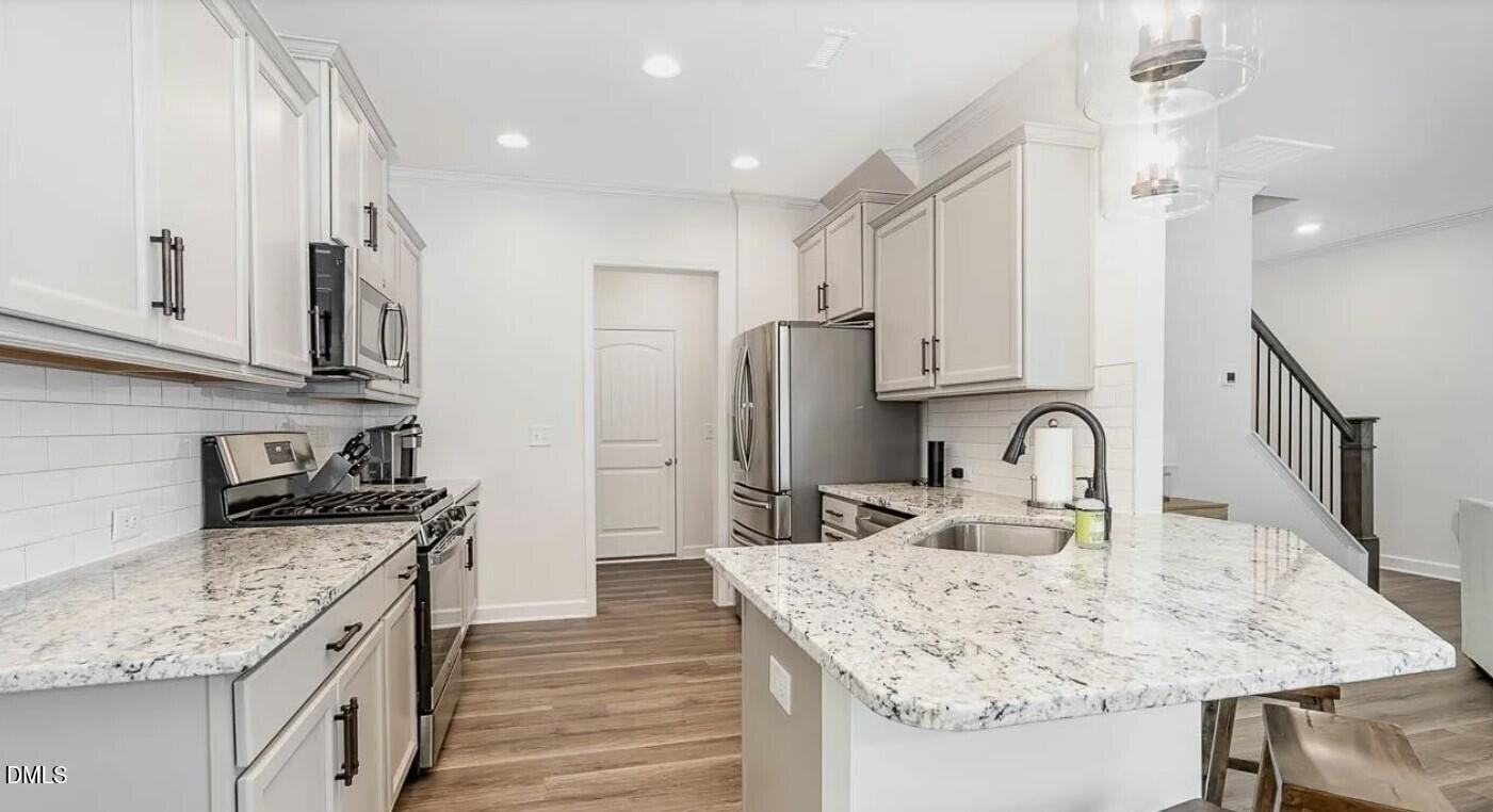 212 Bridge Point Drive Rolesville, NC 27571 - Photo 7 of 13 a kitchen with stainless steel appliances granite countertop a sink stove and refrigerator