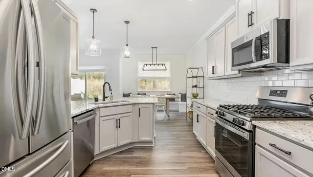 a kitchen with stainless steel appliances a stove a sink and a refrigerator