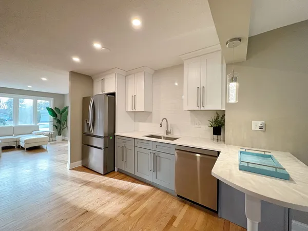 a kitchen with a sink a refrigerator and a stove top oven