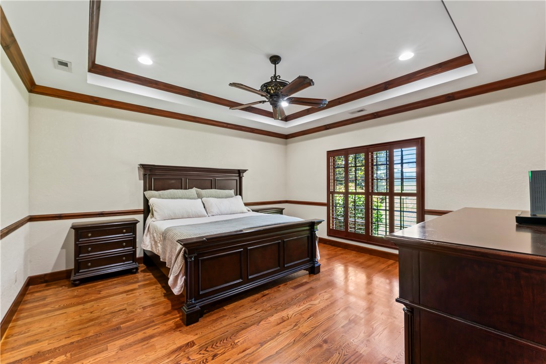 579 Terrapin Crossing Road Pickens, SC 29671 - Photo 15 of 50 Rich hardwood floors complement the primary bedroom with rich wood plantation shutters and a detailed tray ceiling