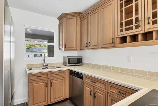 a kitchen with granite countertop cabinets stainless steel appliances and wooden floor