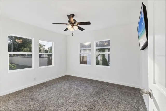 a view of swimming pool with palm trees in front of house