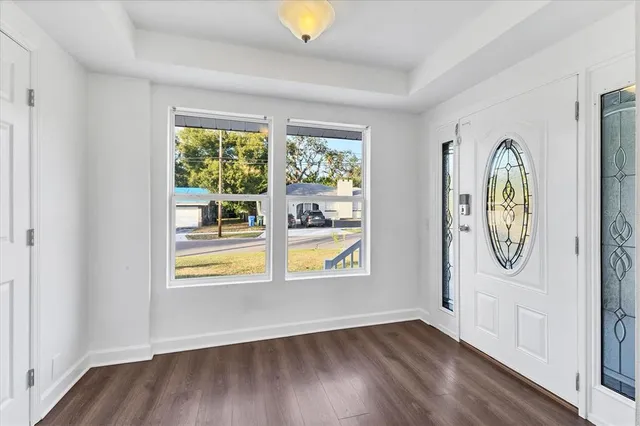 a view of a hallway with wooden floor and a chandelier fan