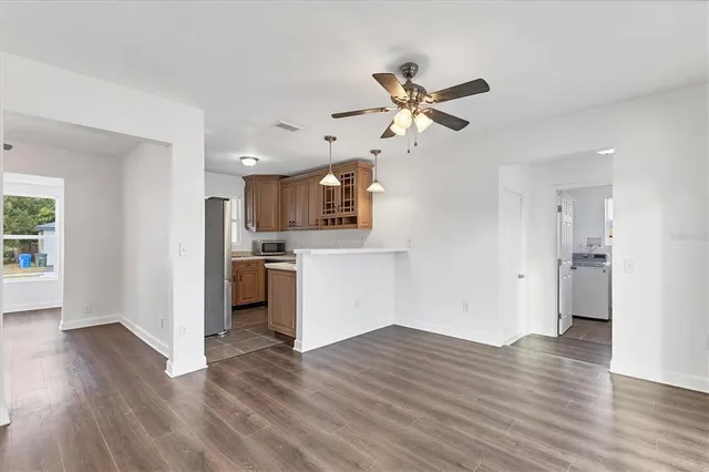 a view of a kitchen with wooden floor and a ceiling fan