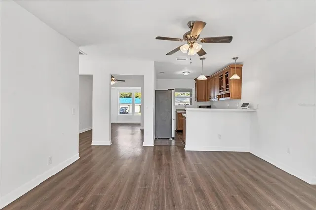 a kitchen with a refrigerator a stove top oven a sink and a potted plant