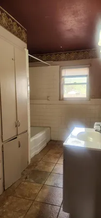 a view of empty room with window and refrigerator