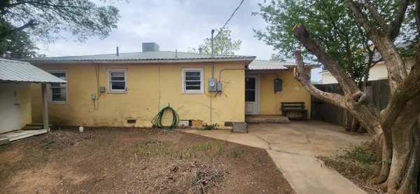 a view of a house with backyard space and a tree