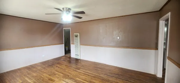 a view of an empty room with wooden floor