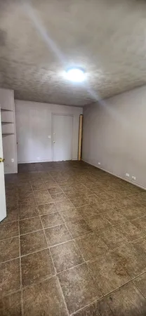 a view of a big room with wooden floor and windows