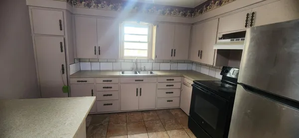 a kitchen with stainless steel appliances a stove microwave and a refrigerator