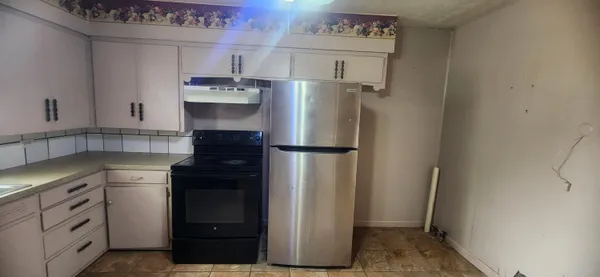 a kitchen with a refrigerator and cabinets