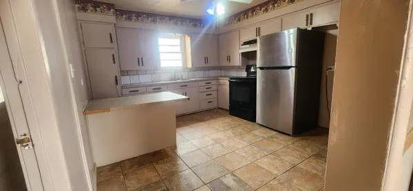a kitchen with a refrigerator sink and cabinets