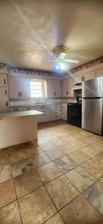 a kitchen with kitchen island a counter top space cabinets and stainless steel appliances
