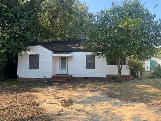 a house that has a tree in front of it