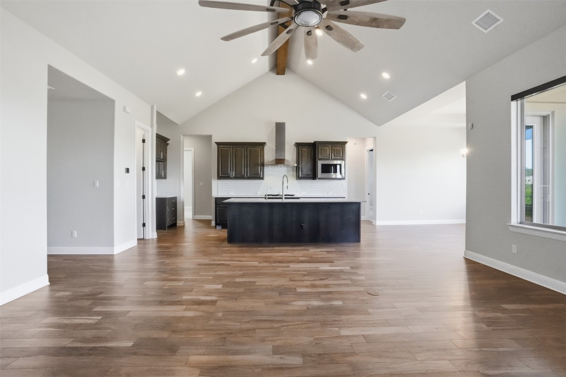 1441 River Vista Road Georgetown, TX 78628 - Photo 17 of 37 Unfurnished living room with beam ceiling, dark wood finished floors, high vaulted ceiling, and a ceiling fan