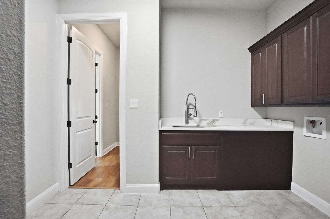 1441 River Vista Road Georgetown, TX 78628 - Photo 20 of 37 Washroom featuring light tile patterned floors, cabinet space, and hookup for a washing machine